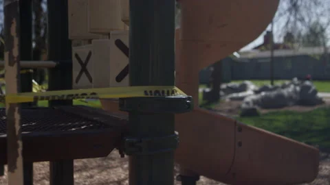 Pan across an empty playground surrounded by caution tape Video stock 130387735