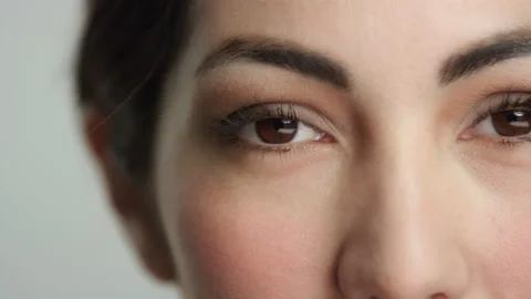 Pan across gorgeous model's brown eyes in extreme closeup, looking to camera Stock Footage 193922897
