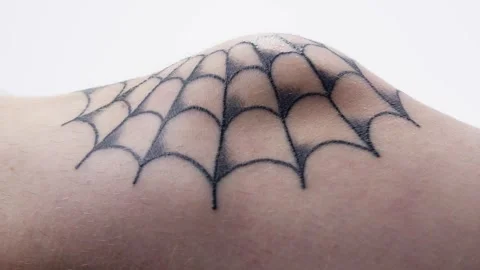 Pan Across a Healing Spider Web Tattoo Design on a Male Knee Stock Footage 276274306