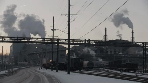 Pan across industrial train yard with factory and smoke stacks Vídeos de archivo 89945284