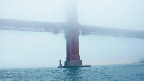 Pan across massive Golden Gate Bridge supports in thick fog, early morning Видео 242828175