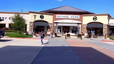Pan across numerous storefronts of premium retailers in outdoor shopping mall Vídeo Stock 165527368