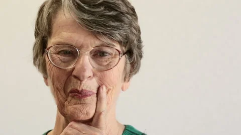 Pan across to old woman's face, nodding and smiling with hand on chin Stock Footage 54288228