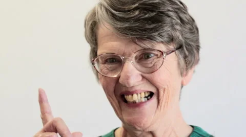Pan across old woman's face; she smiles and wags finger Stock Footage 55499713