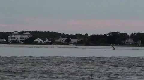 Pan across paddleboarder at dusk in Maryland bay Video stock 40974953