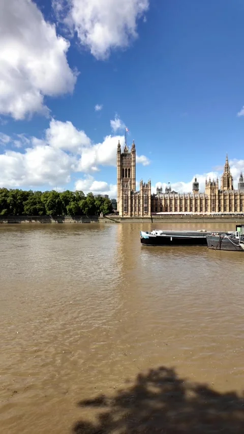 Pan across the River Thames towards Westminster and the Houses of Parliament Video stock 283296819