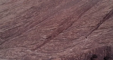 Pan across rock floor texture in front of a desert cliff Stock Footage 93723751