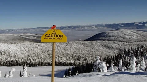 Pan across ski hill terrain and avalanche sign Stock Footage 22478610