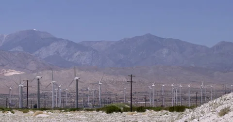 Pan across small and large wind turbines at desert wind farm 4K Stock Footage 63845291