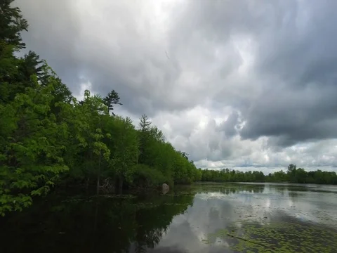 Pan across a small lake on a cloudy day Video stock 76438153