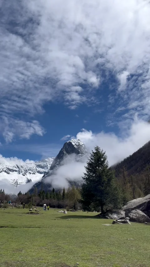 Pan across snow-capped mountain and forest valley in Sichuan, China Stock Footage 337882654