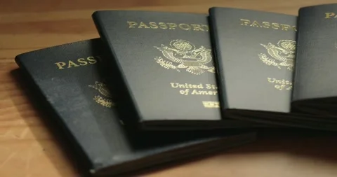 Pan across a stack of USA passports on a wood table Stock Footage 292566024