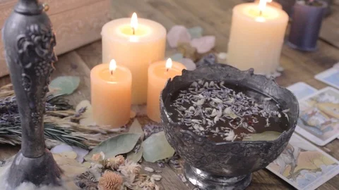 Pan across a table with tarot cards, burning candles and a cauldron. Stock Footage 88604559