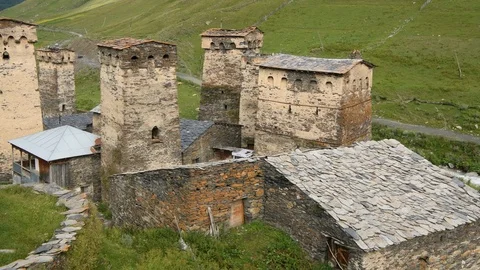 Pan across wide of the stone medieval fortified Svaneti tower houses of  Ushguli Stock Footage 104623203