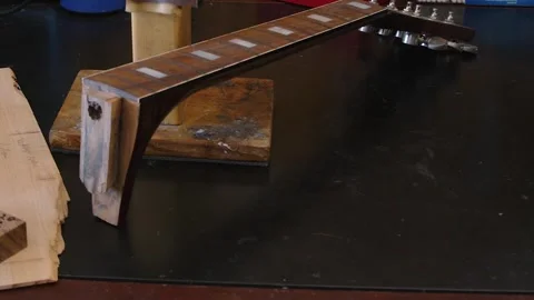 Pan across workbench with frets, neck and acoustic guitar body parts Stock Footage 331294080