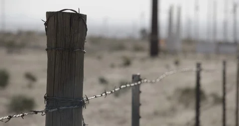 Pan Along Barbed Wire Fence in Desert Meadow Stock Footage 89942657