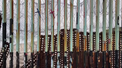 Pan along the border wall that separates Mexico and the United States. The Stock Footage 245995397