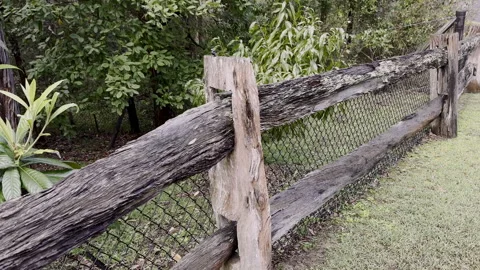 Pan along old rustic wooden fence with thick wooden posts Stock Footage 242015079