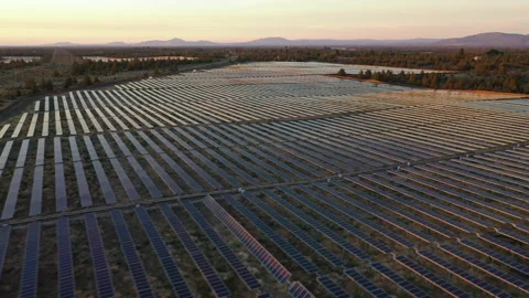 Pan and track over solar farm at sunset Stock Footage 160888105