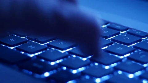 Pan around man typing on blue computer keyboard Stock Footage 85163062