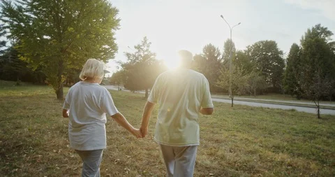 Pan around tracking shot of cheerful elderly athletes holding hands and talking Video stock 129682261