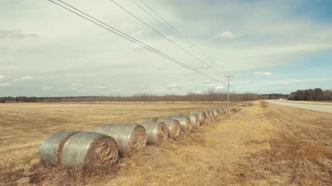 Pan away from traffic on highway 1 and hay bales on farm land Stock Footage 147233932