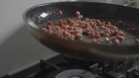 A pan of bacon is cooking on a stove Stock Footage 306042891