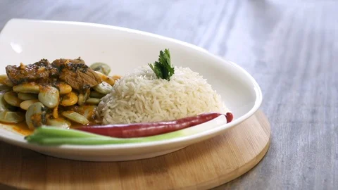 Pan on bean stew dish cooked with beef and served with rice, onion, and pepper Stock Footage 122449438