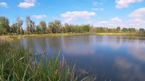 Pan of a beautiful lake in the Fall with cloudy blue skies Stock Footage 143362957