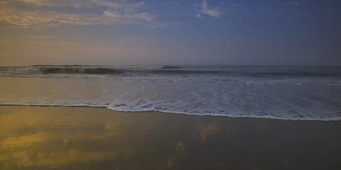 Pan of beautiful ocean, dramatic sky and pier at a distance Stock Footage 103494837