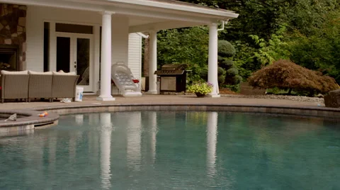 Pan of a beautiful pool and poolhouse in the mountains, in slow motion Stock Footage 58894065