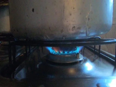 Pan being heated by stove fire with blue flame Stock Footage 112074046