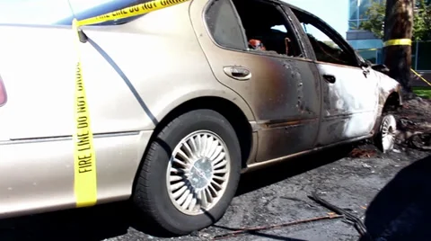 Pan beside burnt car with fire caution tape Video stock 32113701