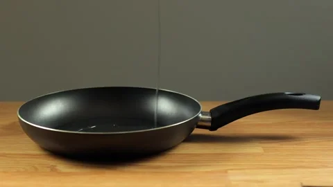 The pan is black on the table. A frying pan Stock Footage 273286897
