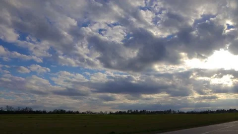 Pan of a blue sky with dark storm clouds and sun rays beaming through the clo Stock Footage 149053757