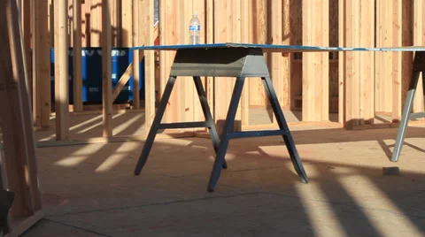 PAN OF BUILDING BEING BUILD RAW 2X4'S AND BUILDING MATERALS. Stock Footage 33756294