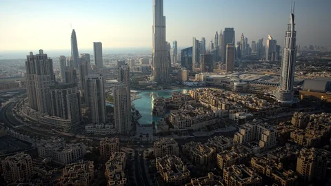 Pan up Burj Khalifa while tracking left over Downtown Dubai at 150m. Stock Footage 98942346