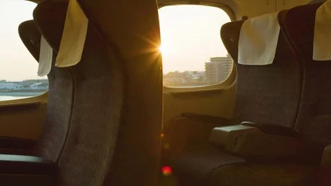 Pan of cabin inside of commuter bullet train window at sunset with flares. Stock Footage 125720018