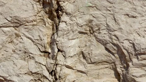 Pan camera of Solid rock close-up. Structure and texture of the stone rock. Natu Stock Footage 159085955