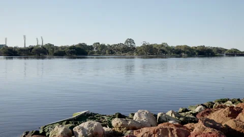 Pan from casino to Perth City from across pristine River under cloudless sky Stock Footage 159130341
