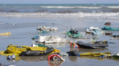 Pan close up shot of plastic garbage and trash on beach on sea background Stock Footage 51025863