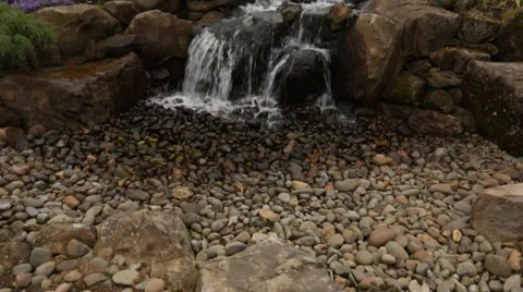 Pan Up of Cross at Lanscaped Waterfall Stock Footage 34403953