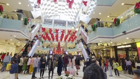 Pan crowded shopping mall with notable brands and crowded with people on Stock Footage 328704563