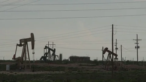 Pan dark sky to see multiple oil pump jacks working, 4K. Stock Footage 79979277