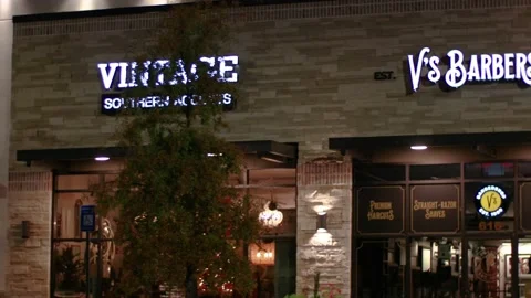 Pan of Diablos restaurant and various retail stores at night Stock Footage 143810479