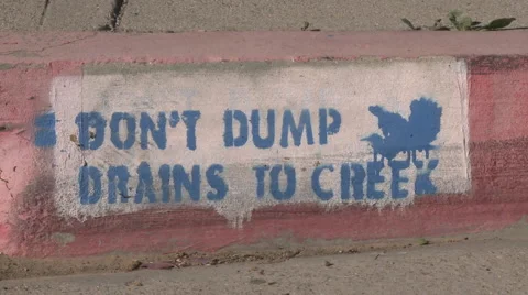Pan of a Don't Dump Drains to Creek sign in Ojai, California. Stock Footage 1027499