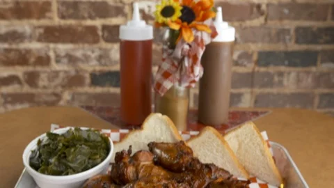 Pan down of BBQ chicken wings with sides  Stock Footage 112576181