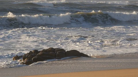 Pan down from blue sky to ocean waves breaking on sandy beach with rock Stock Footage 103282281