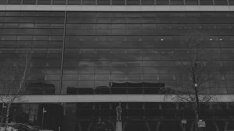 Pan down on building to reveal man walking on sidewalk Video stock 171835982
