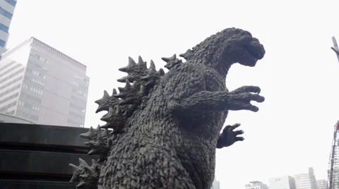 Pan down from buildings to a Godzilla statue in Tokyo, Japan Video stock 57139825